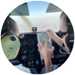 ϲ cadets in the aviation club fly in a plane over post, reviewing a map.