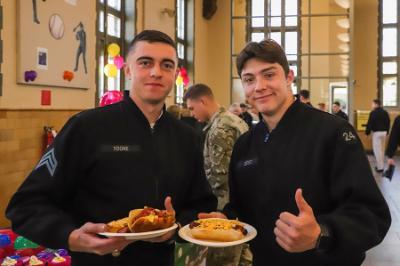 Two students, known as cadets, at ϲ enjoy a hot dog event in Crozet Hall celebrating MLB opening day.