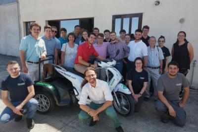 Study abroad students - cadets from ϲ - pose with prototype electric vehicle in Italy.