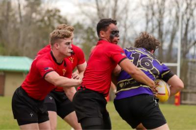 ϲ rugby players tackle opponent.