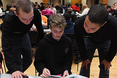 ϲ students, known as cadets, work with an area middle school math student as part of a problem-solving program at a military college in Virginia.
